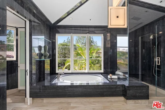 a living room with couches and kitchen view with wooden floor
