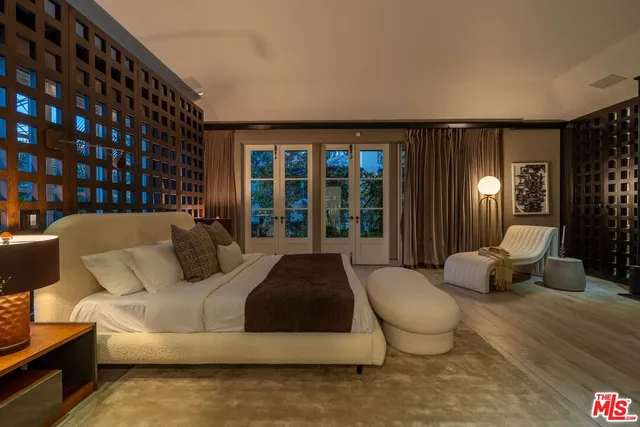 a large kitchen with stainless steel appliances a large counter top a stove a sink and a refrigerator