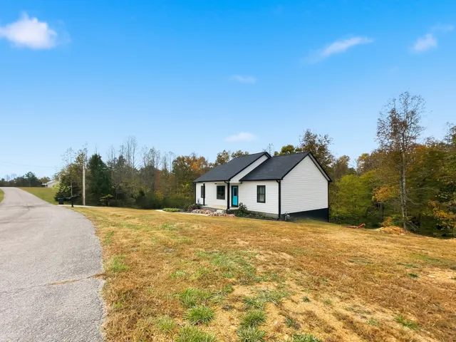 a view of a large house with a big yard and large trees
