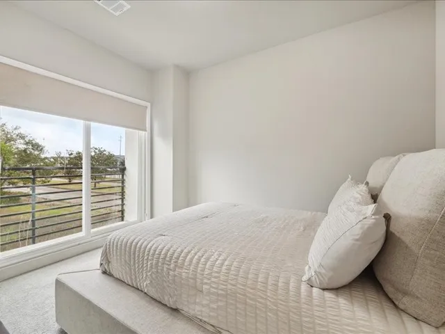 a bedroom with a bed and a large window