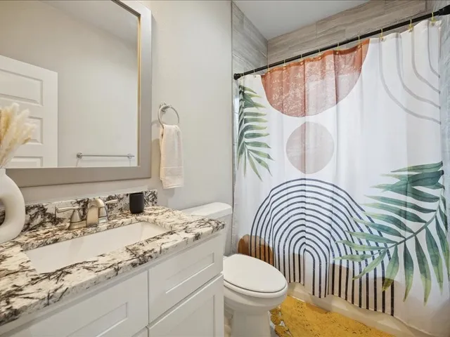 a bathroom with a sink a toilet and a mirror