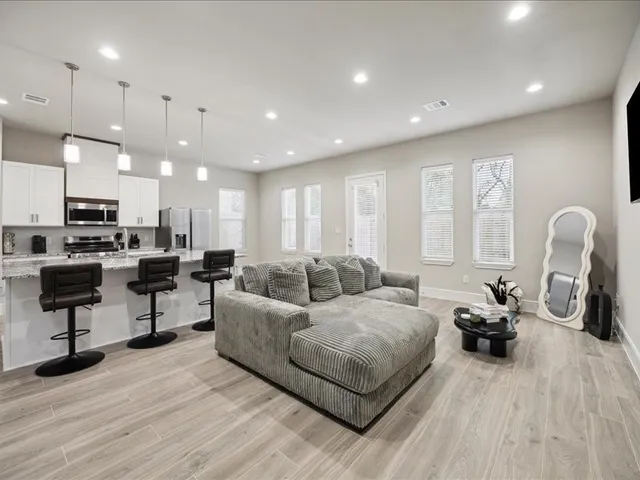 a living room with furniture and a wooden floor