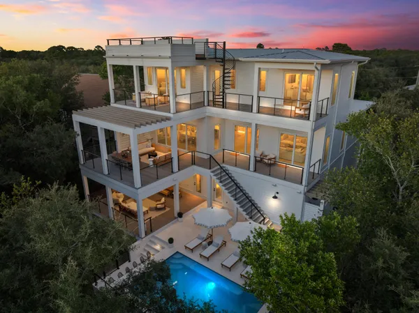 aerial view of a house with balcony and trees al around