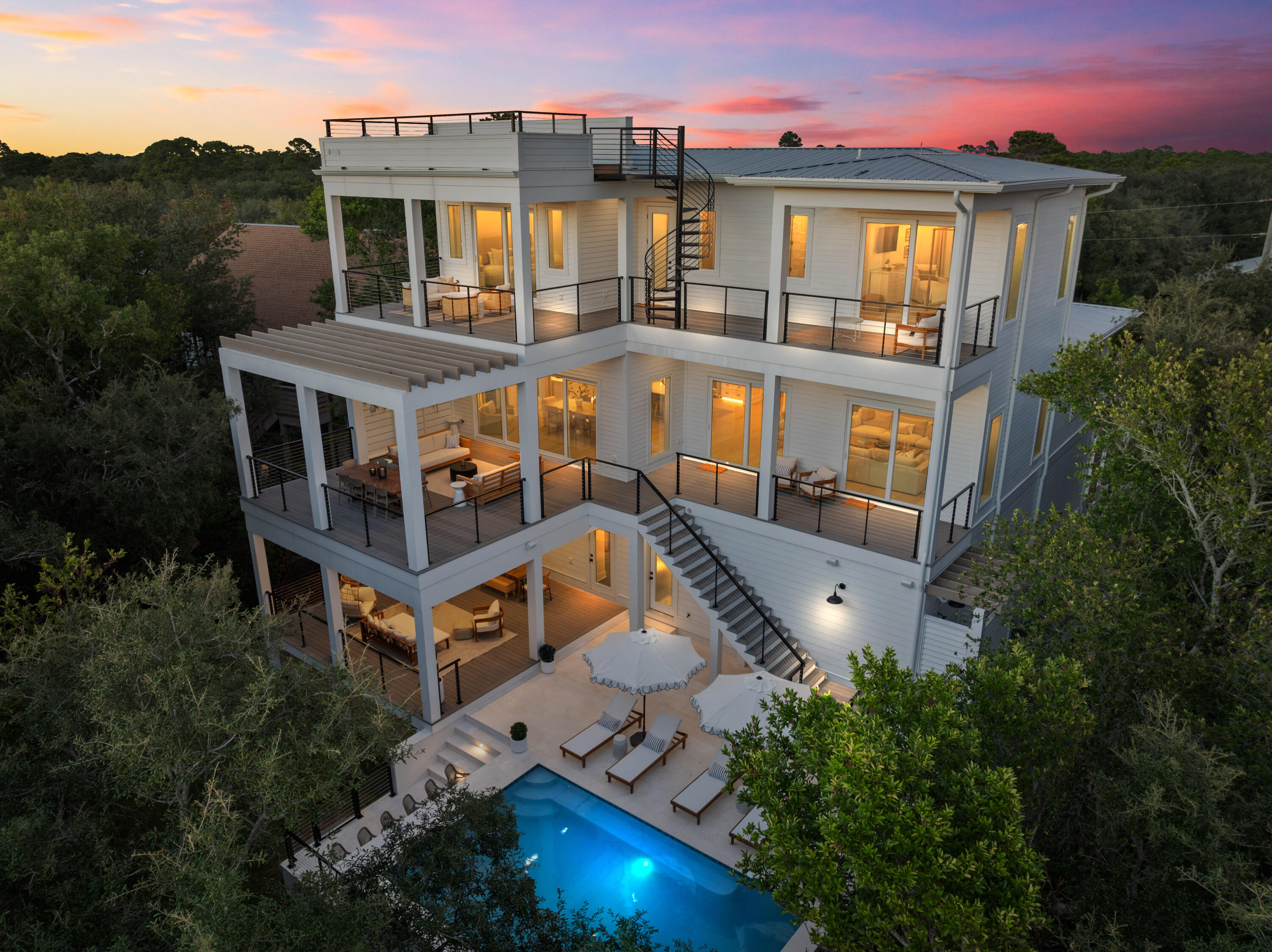 aerial view of a house with balcony and trees al around