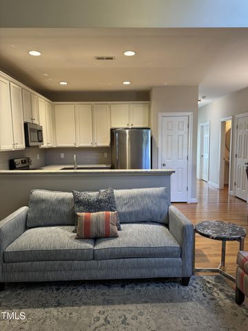 a living room with furniture and kitchen view