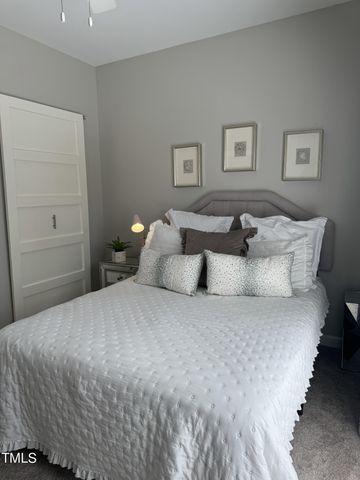 a spacious bedroom with a bed and a lamp