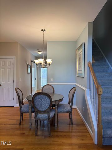 a dining room with furniture a chandelier and wooden floor