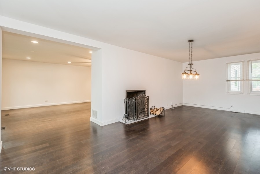 8640 East Prairie Road Skokie, IL 60076 - Photo 3 of 39 a view of a room with wooden floor and windows
