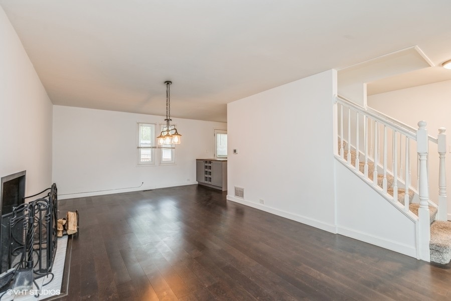 8640 East Prairie Road Skokie, IL 60076 - Photo 5 of 39 a view of an empty room with wooden floor and a window