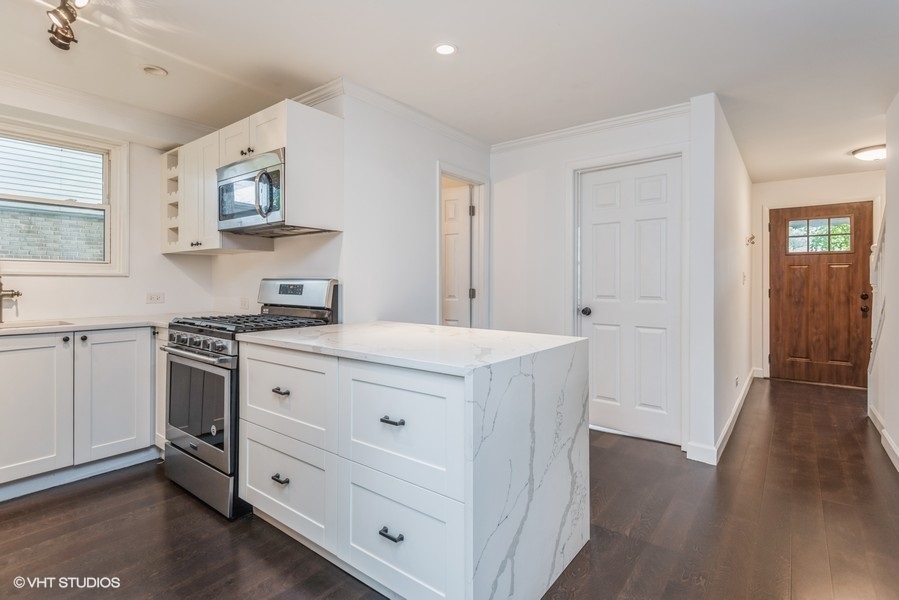 8640 East Prairie Road Skokie, IL 60076 - Photo 8 of 39 a kitchen with cabinets stove and wooden floor