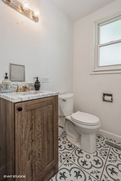 8640 East Prairie Road Skokie, IL 60076 - Photo 9 of 39 a bathroom with a toilet a sink and a window