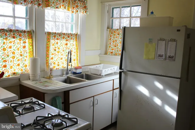 a kitchen with stainless steel appliances kitchen island granite countertop a sink stove and refrigerator
