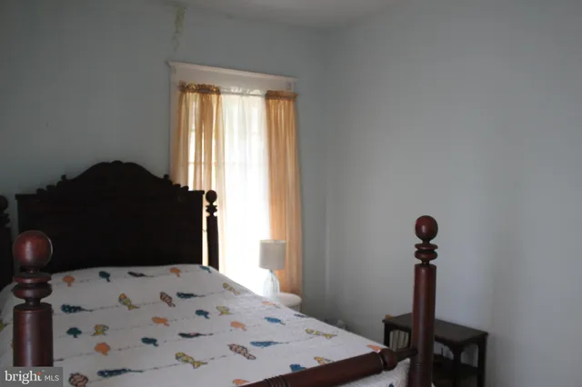 a bedroom with a bed dresser and a window