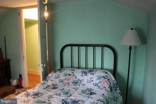 a bedroom with a bed and a flat tv screen next to a window