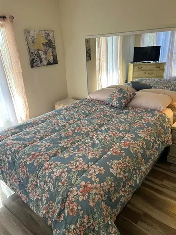 a bedroom with a bed and wooden floor