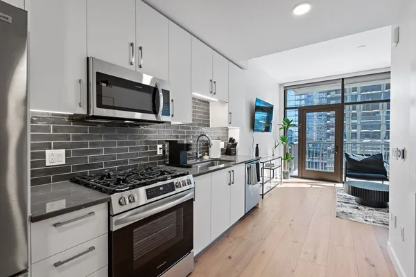 a kitchen with stainless steel appliances a stove sink microwave and cabinets