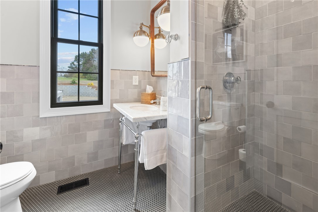 677 Lightwood Road Hartwell, GA 30643 - Photo 17 of 42 This primary bathroom features a charming window and a glass-enclosed shower, perfect for a refreshing start to your day.