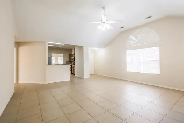 an empty room with chandelier and windows