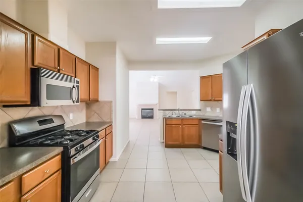 a kitchen with stainless steel appliances granite countertop a refrigerator stove and sink