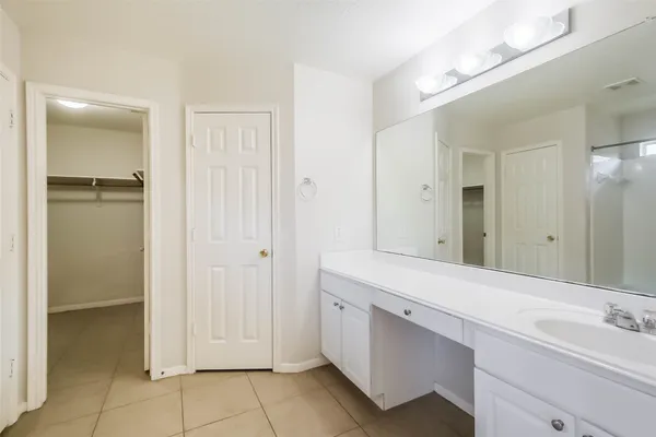 a spacious bathroom with a double vanity sink a mirror and a shower
