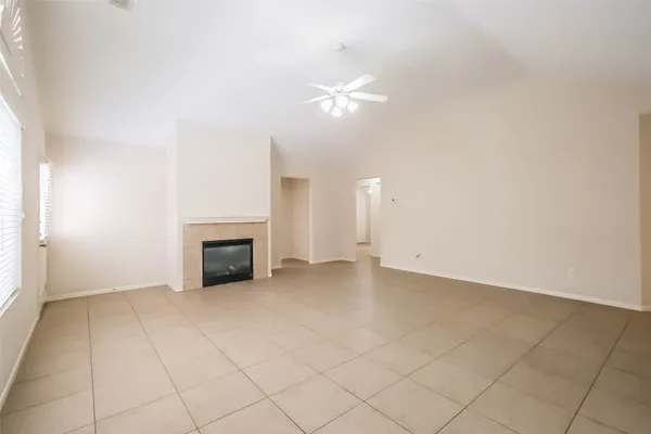 an empty room with fireplace and fan