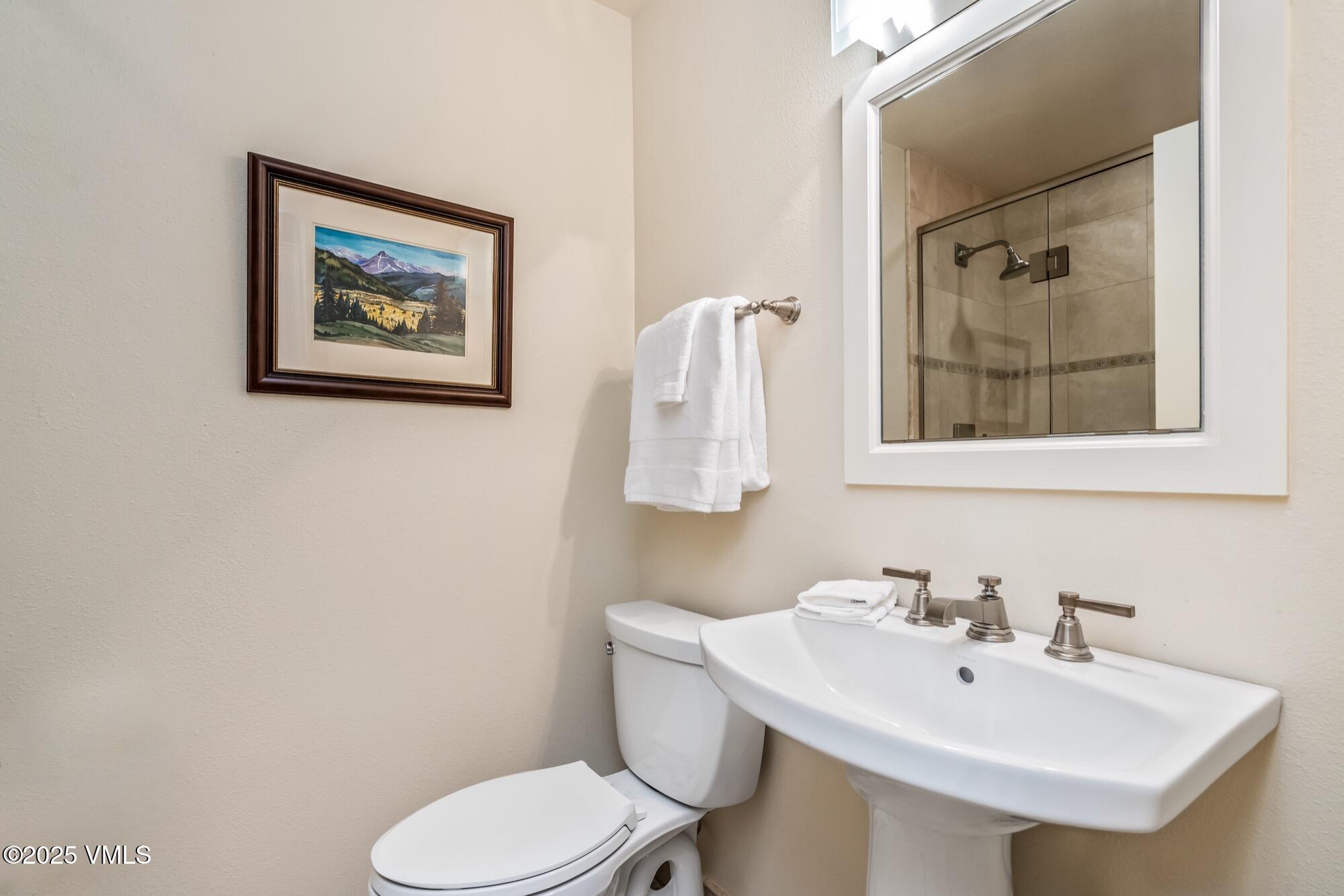 945 Red Sandstone Road, Unit A5 Vail, CO 81657 - Photo 29 of 38 a bathroom with a toilet a sink and mirror