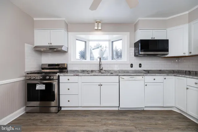 a kitchen with granite countertop a stove and a sink