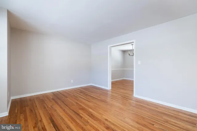 a view of an empty room with wooden floor and closet