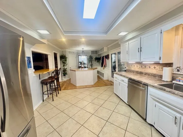 a kitchen with stainless steel appliances granite countertop a refrigerator and a stove top oven