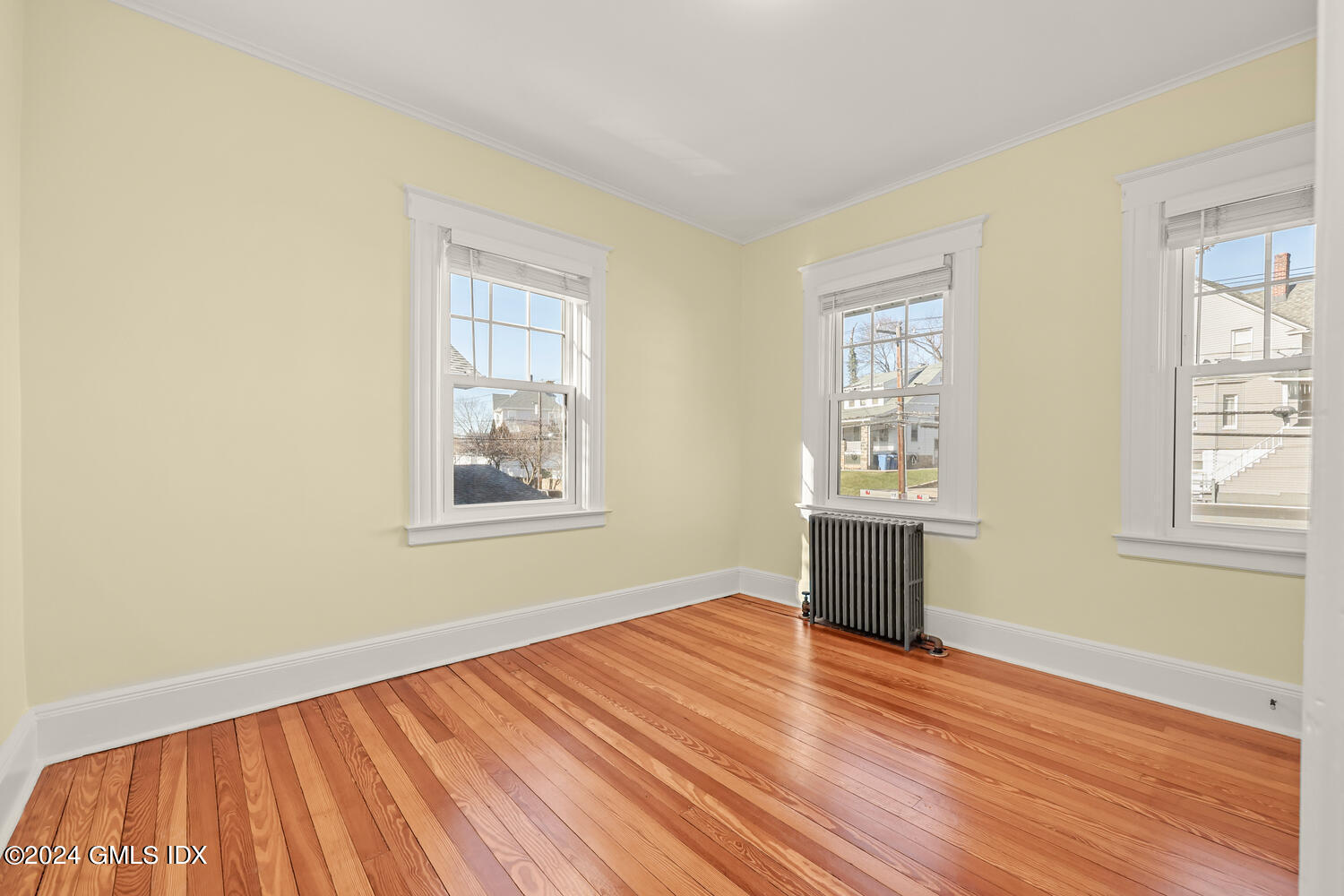 328 Delavan Avenue Greenwich, CT 06830 - Photo 19 of 29 an empty room with wooden floor and windows