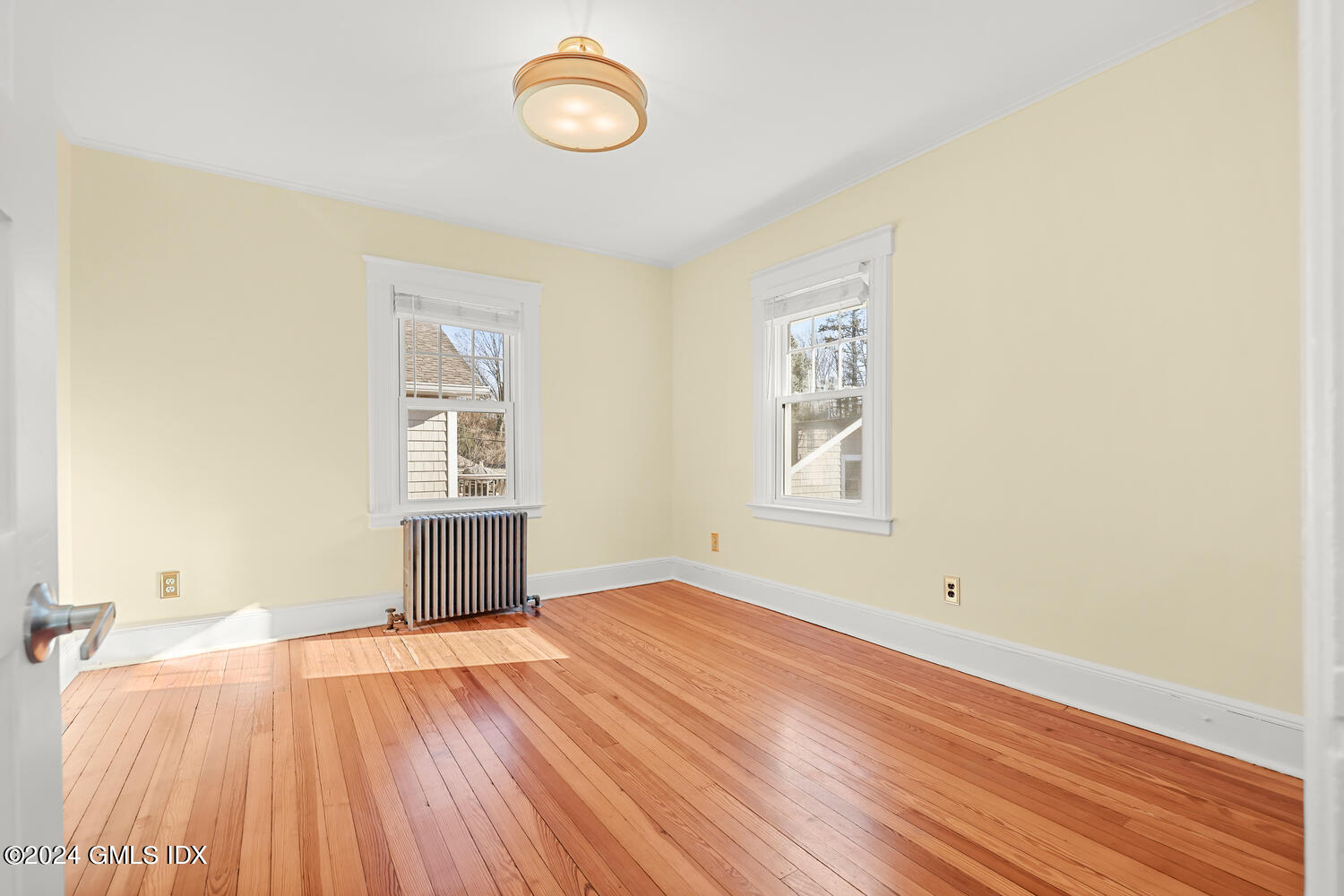 328 Delavan Avenue Greenwich, CT 06830 - Photo 20 of 29 an empty room with wooden floor and windows