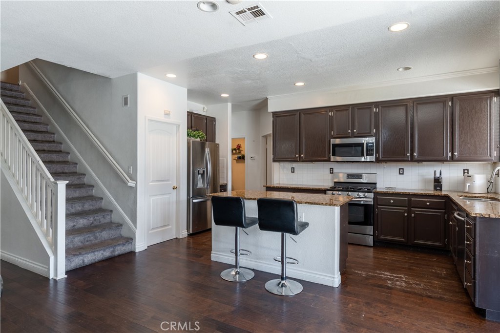 3807 Seattle Street Hemet, CA 92545 - Photo 7 of 37 a kitchen with stainless steel appliances granite countertop a refrigerator and a stove top oven