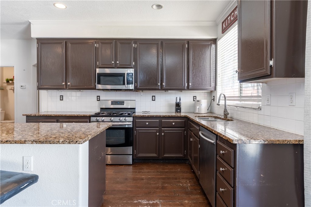 3807 Seattle Street Hemet, CA 92545 - Photo 8 of 37 a kitchen with granite countertop wooden cabinets and stainless steel appliances