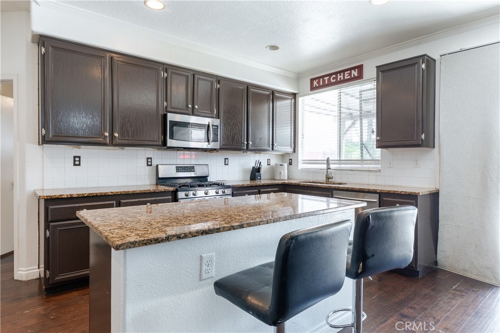 3807 Seattle Street Hemet, CA 92545 - Photo 9 of 37 a kitchen with stainless steel appliances granite countertop a sink stove and microwave