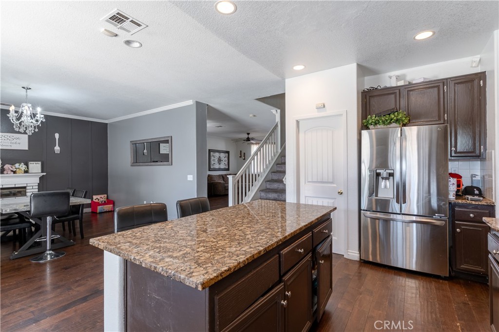 3807 Seattle Street Hemet, CA 92545 - Photo 10 of 37 a kitchen with stainless steel appliances kitchen island granite countertop a refrigerator and a stove