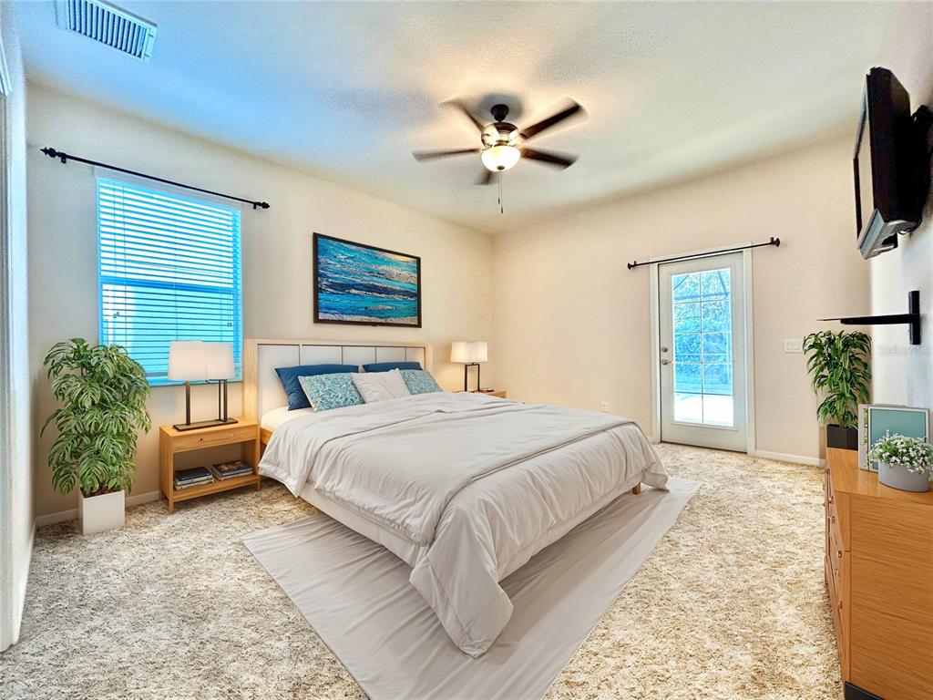 11210 Roseate Drive Tampa, FL 33626 - Photo 20 of 50 a bedroom with a large bed and a chandelier