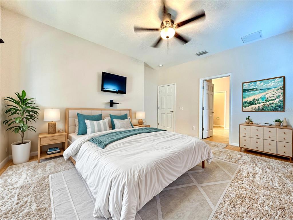 11210 Roseate Drive Tampa, FL 33626 - Photo 22 of 50 a bedroom with a bed a potted plant on the dresser and a table