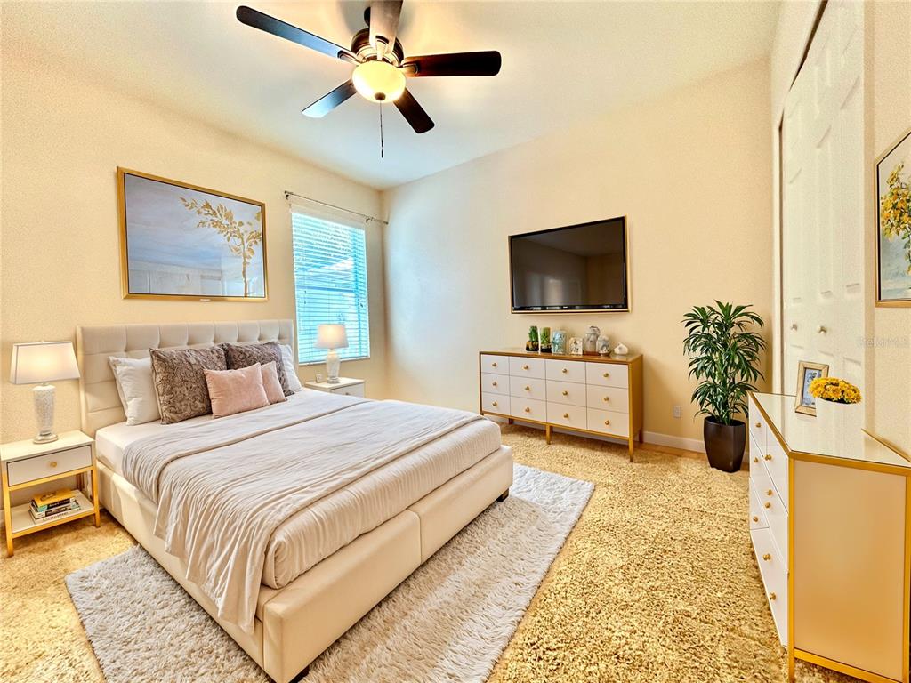 11210 Roseate Drive Tampa, FL 33626 - Photo 24 of 50 a bedroom with a bed a couch and a flat screen tv