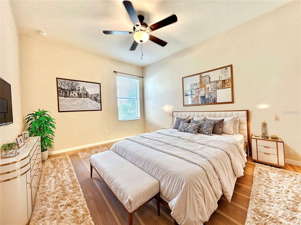 11210 Roseate Drive Tampa, FL 33626 - Photo 26 of 50 a spacious bedroom with a bed and a chandelier
