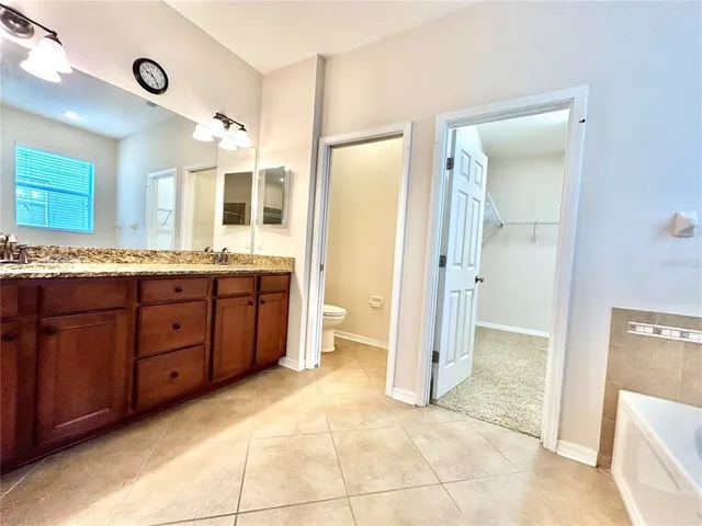 a spacious bathroom with a granite countertop sink mirror and a