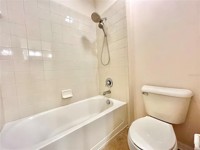 a white toilet sitting next to a bath tub and shower