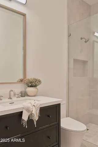 a bathroom with a sink a toilet and mirror