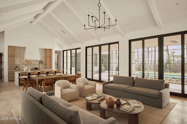 a living room with furniture kitchen view and a large window
