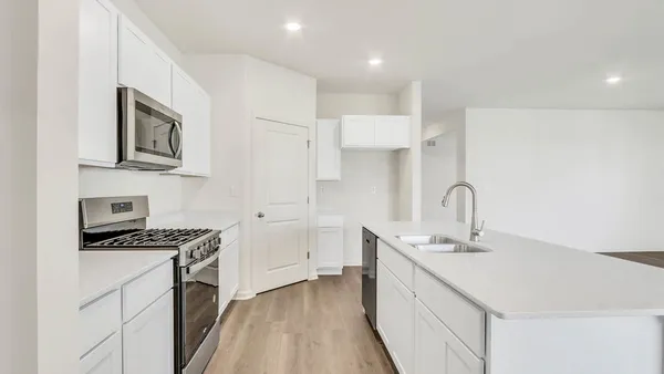 a kitchen with stainless steel appliances a sink stove and cabinets