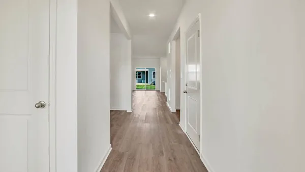 a view of a hallway with wooden floor