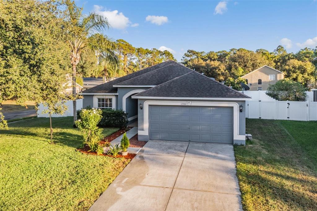 12204 Luftburrow Lane Hudson, FL 34669 - Photo 1 of 33 a front view of a house with a yard and garage