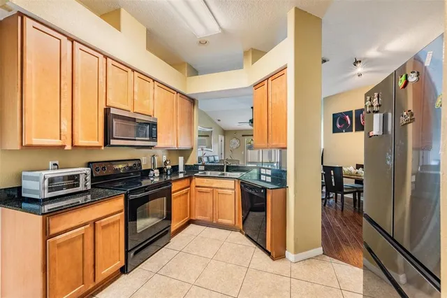 a kitchen with granite countertop a refrigerator and a stove