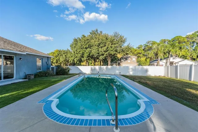 a kitchen with granite countertop a sink a stove top oven and cabinetry