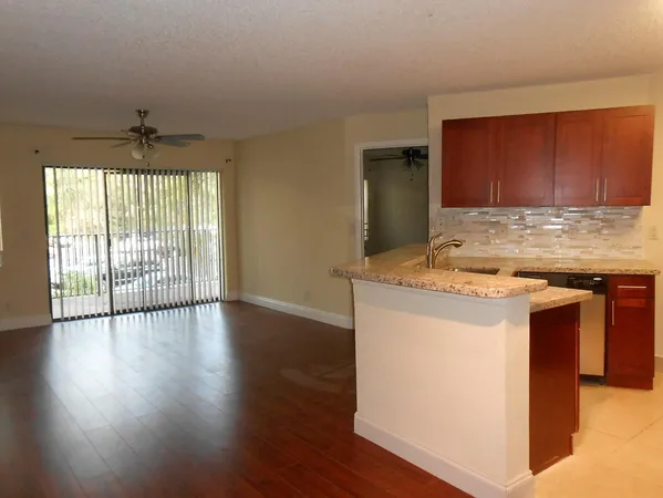 a kitchen with a wooden floor and a large window