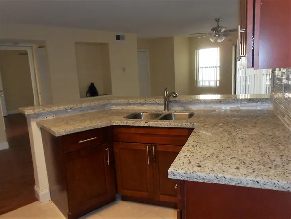 a bathroom with a granite countertop sink and a mirror